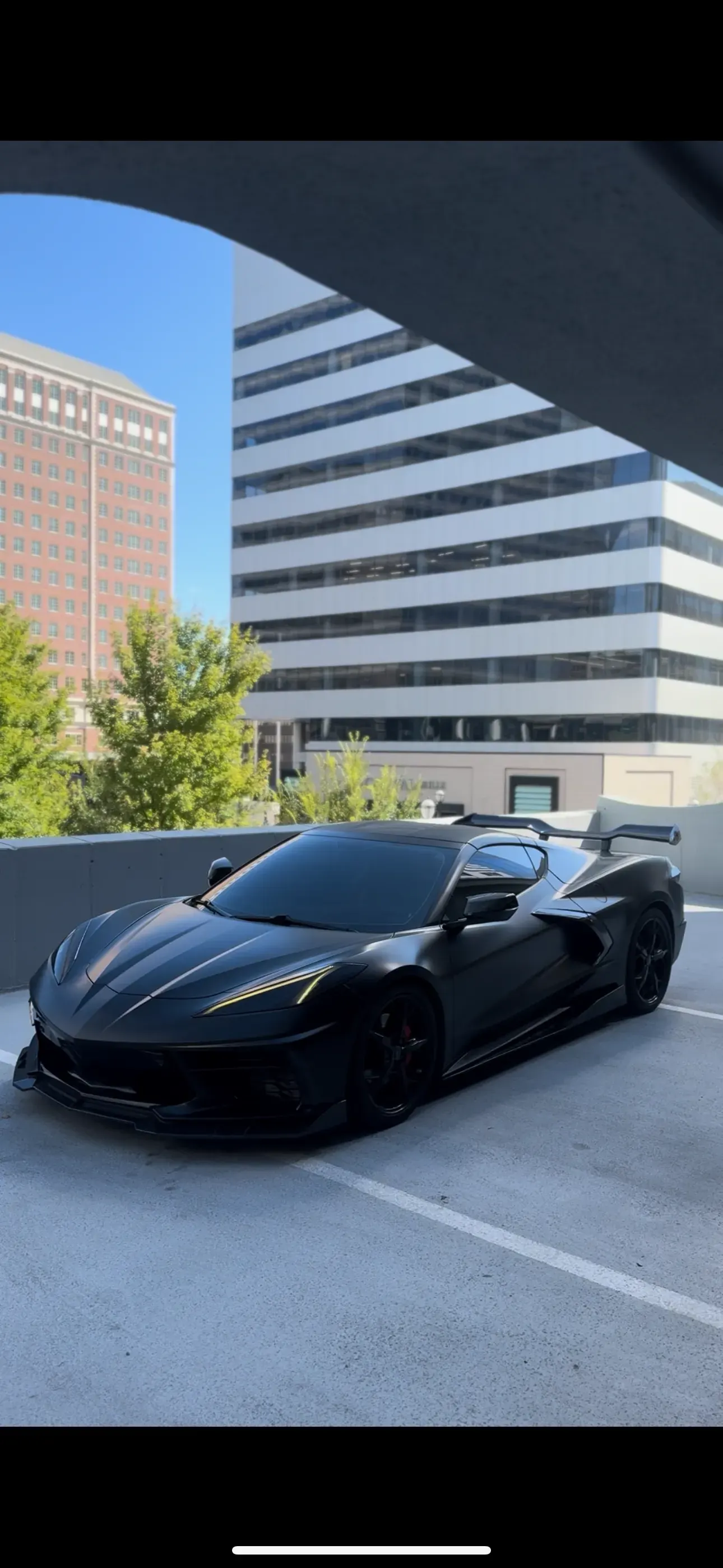 Black wrapped Corvette in a parking garage