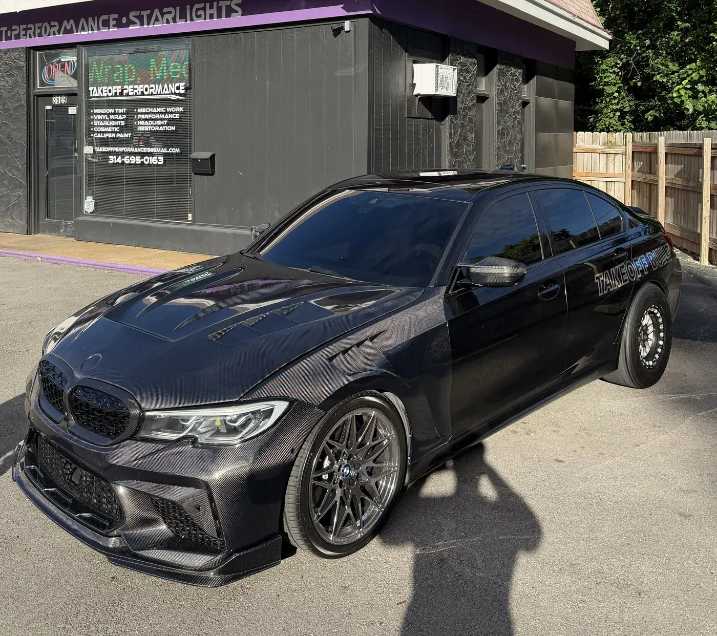 Black BMW with paint protection film outside the shop