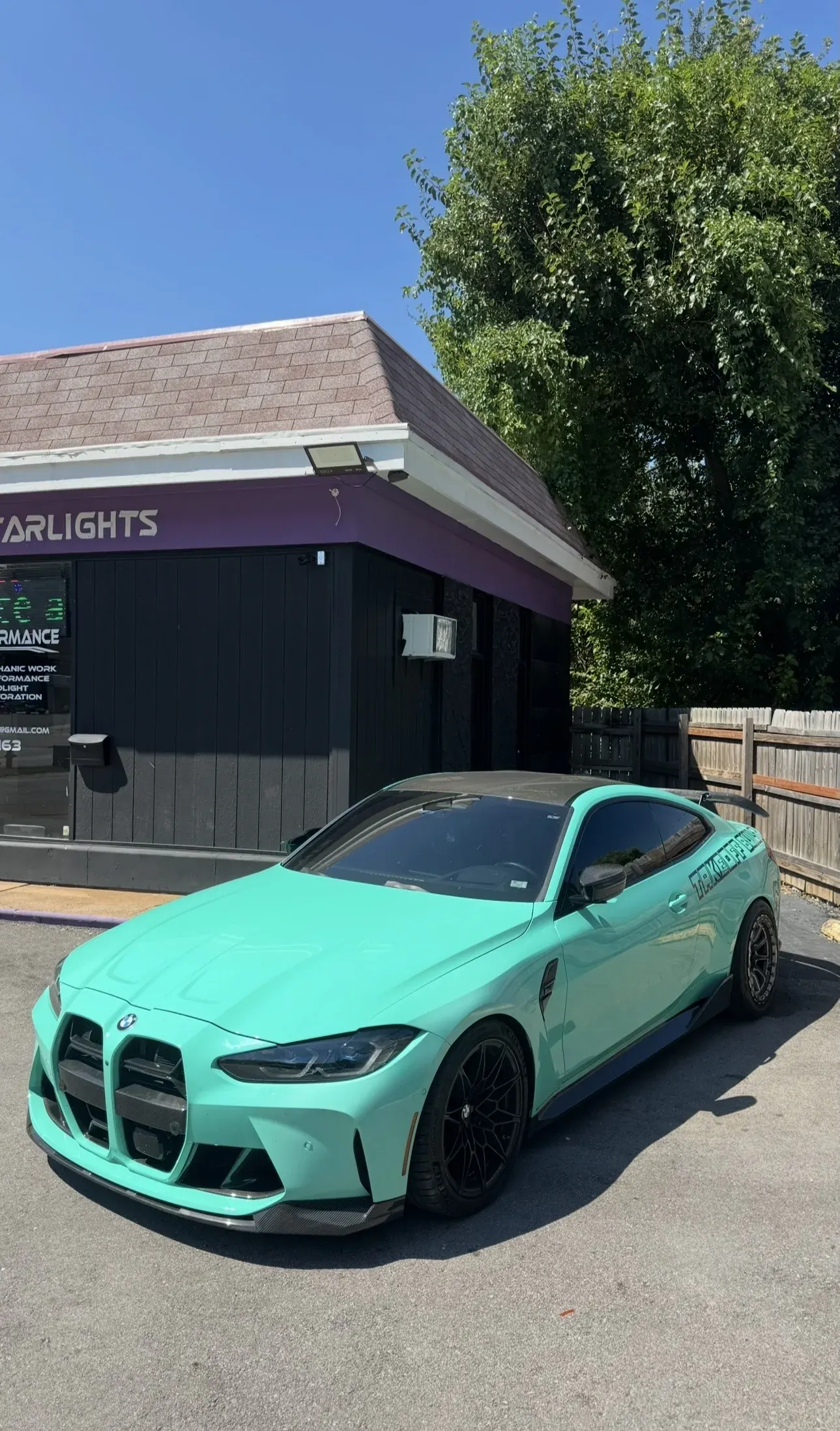 Mint green BMW M4 in front of the shop