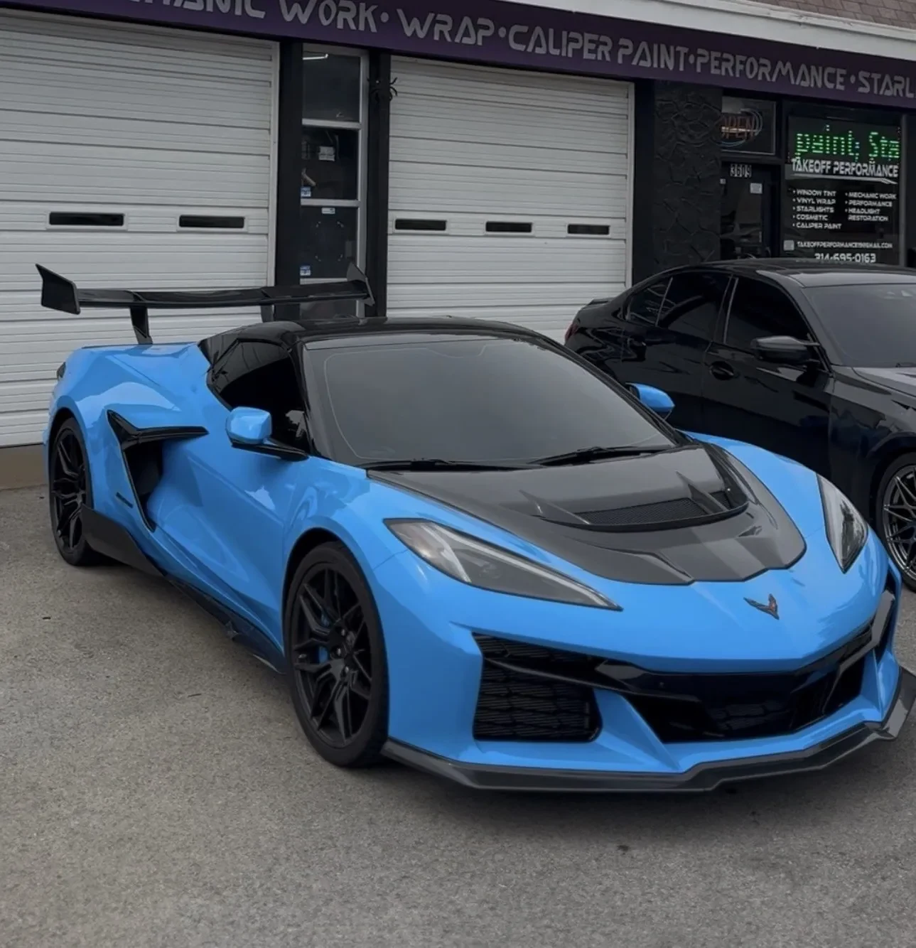Blue Corvette with a carbon hood in the shop bay