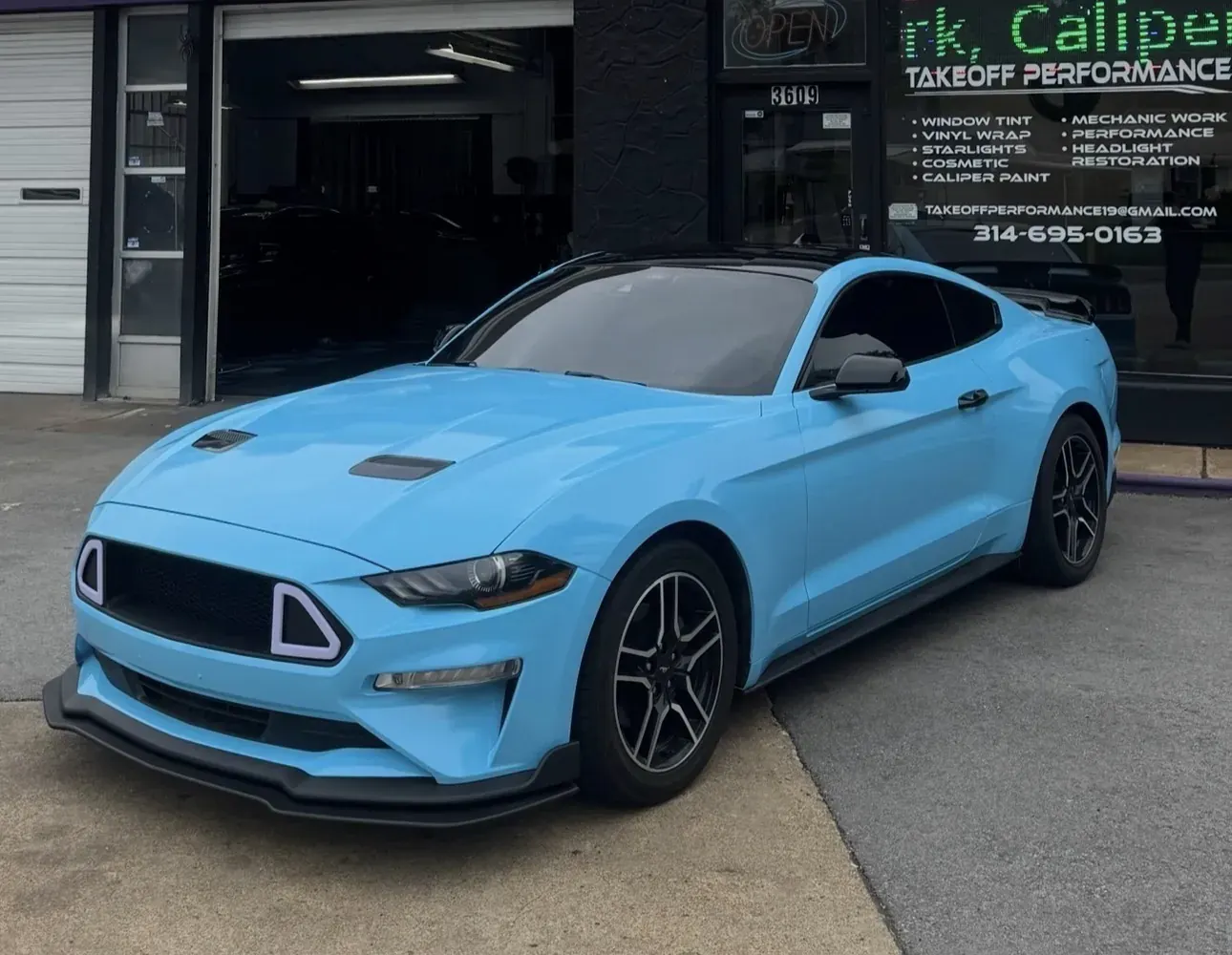 Light blue Mustang in front of the shop