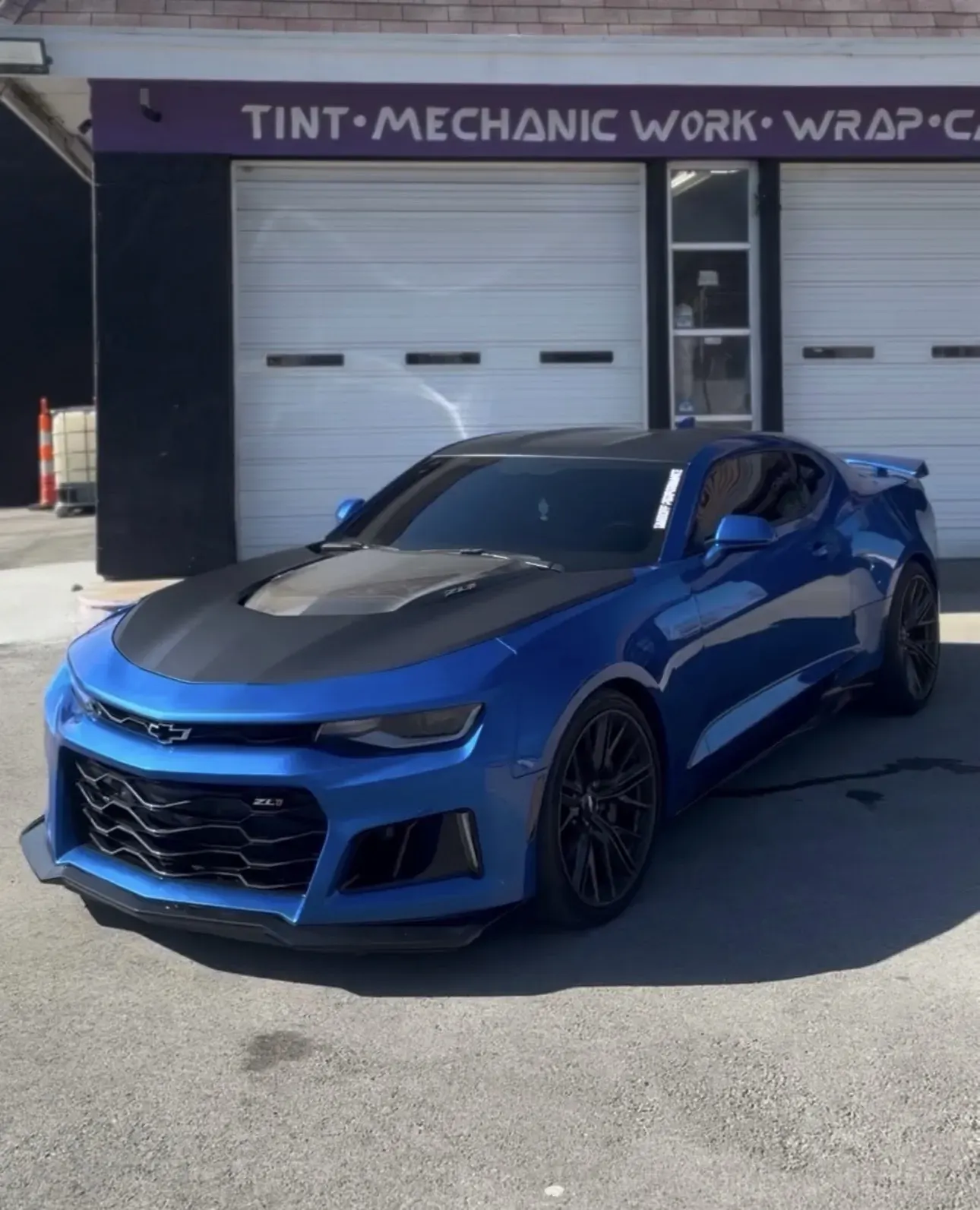 Blue wrapped Camaro ZL1 in front of the shop