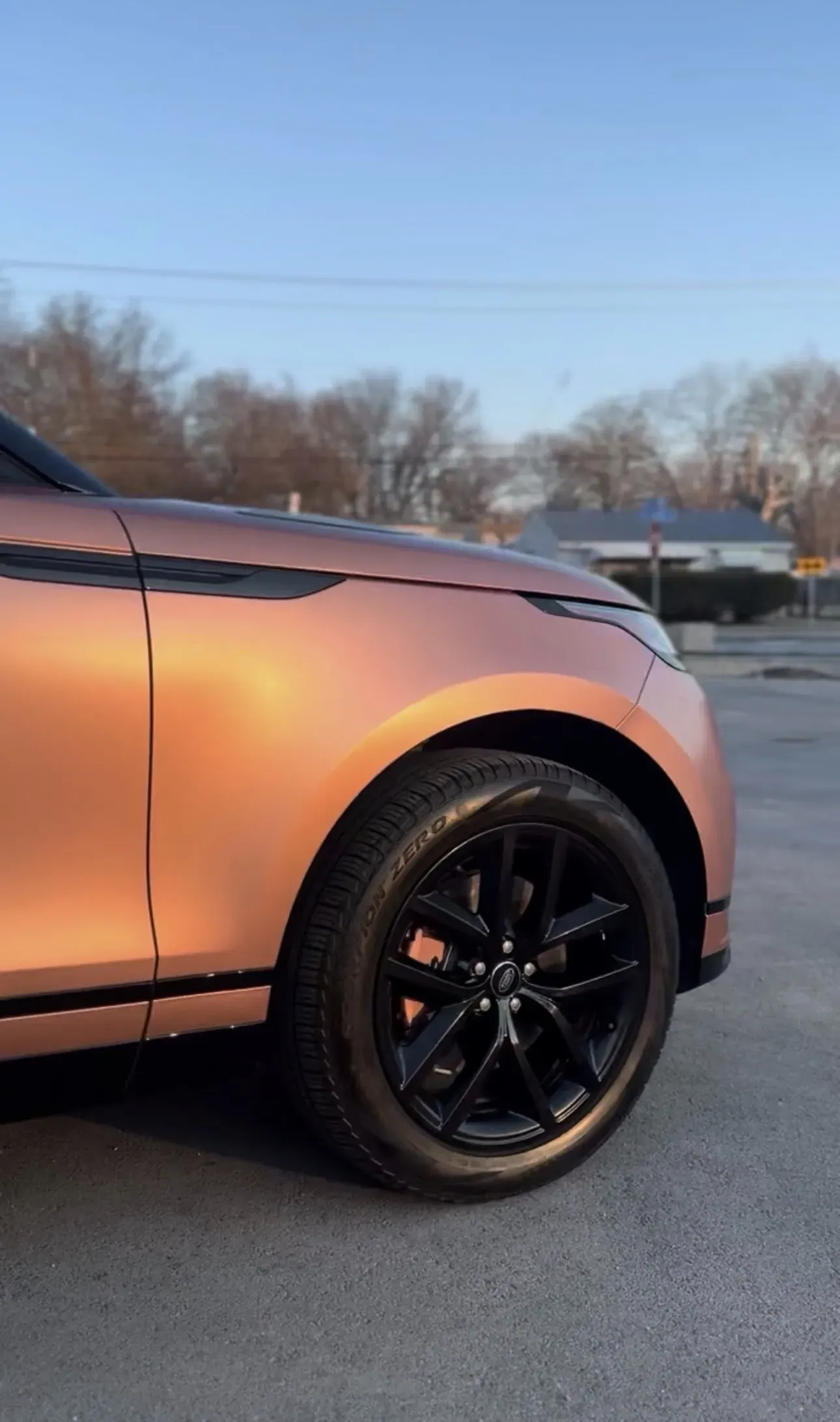 Painted caliper behind a black wheel on an orange car