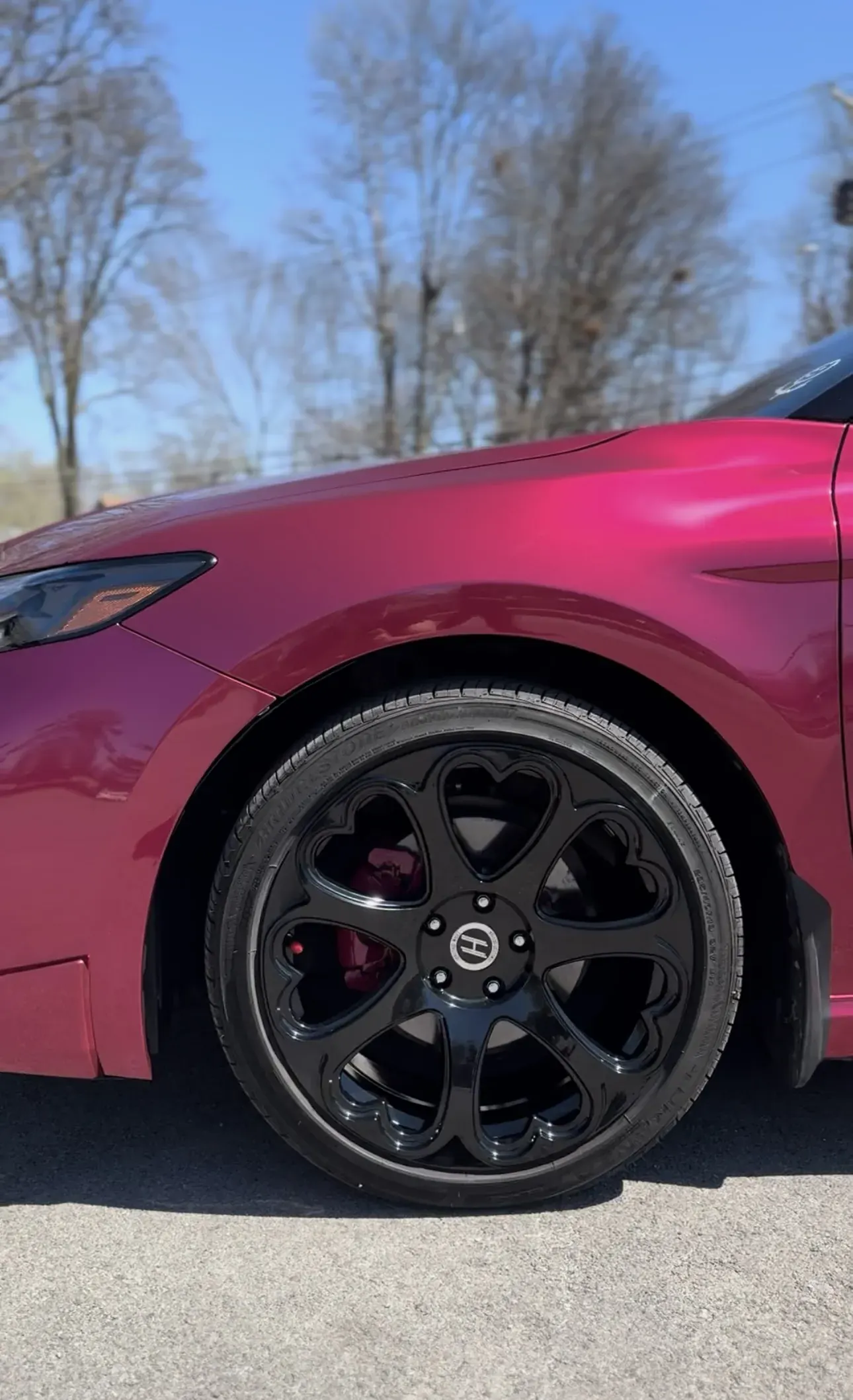 Red painted caliper behind a black wheel