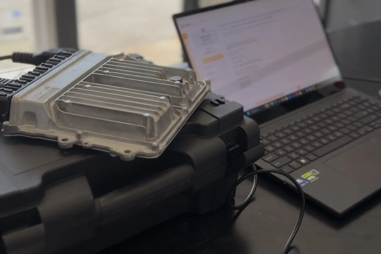 BMW DME on a case beside a laptop