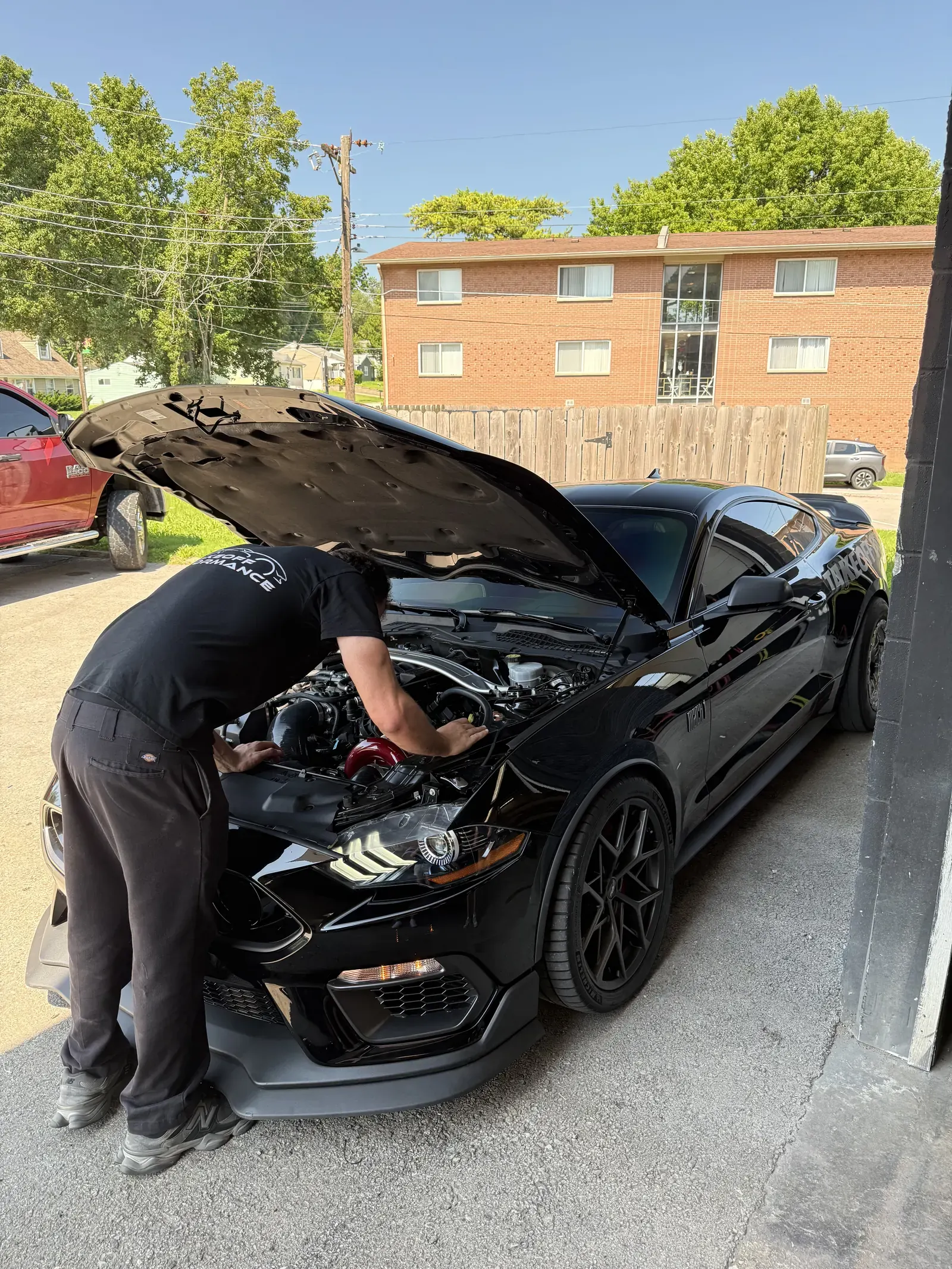Technician working under the hood of a Mustang