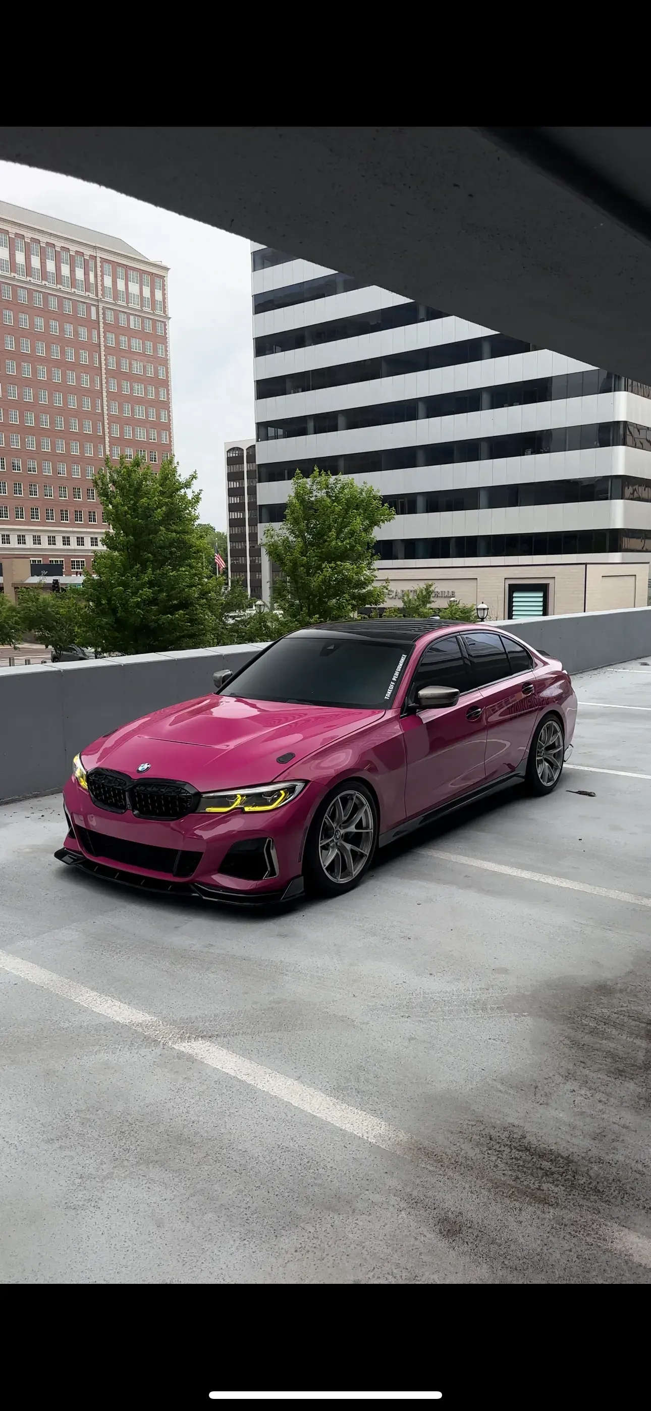 BMW in a pink wrap in a parking garage
